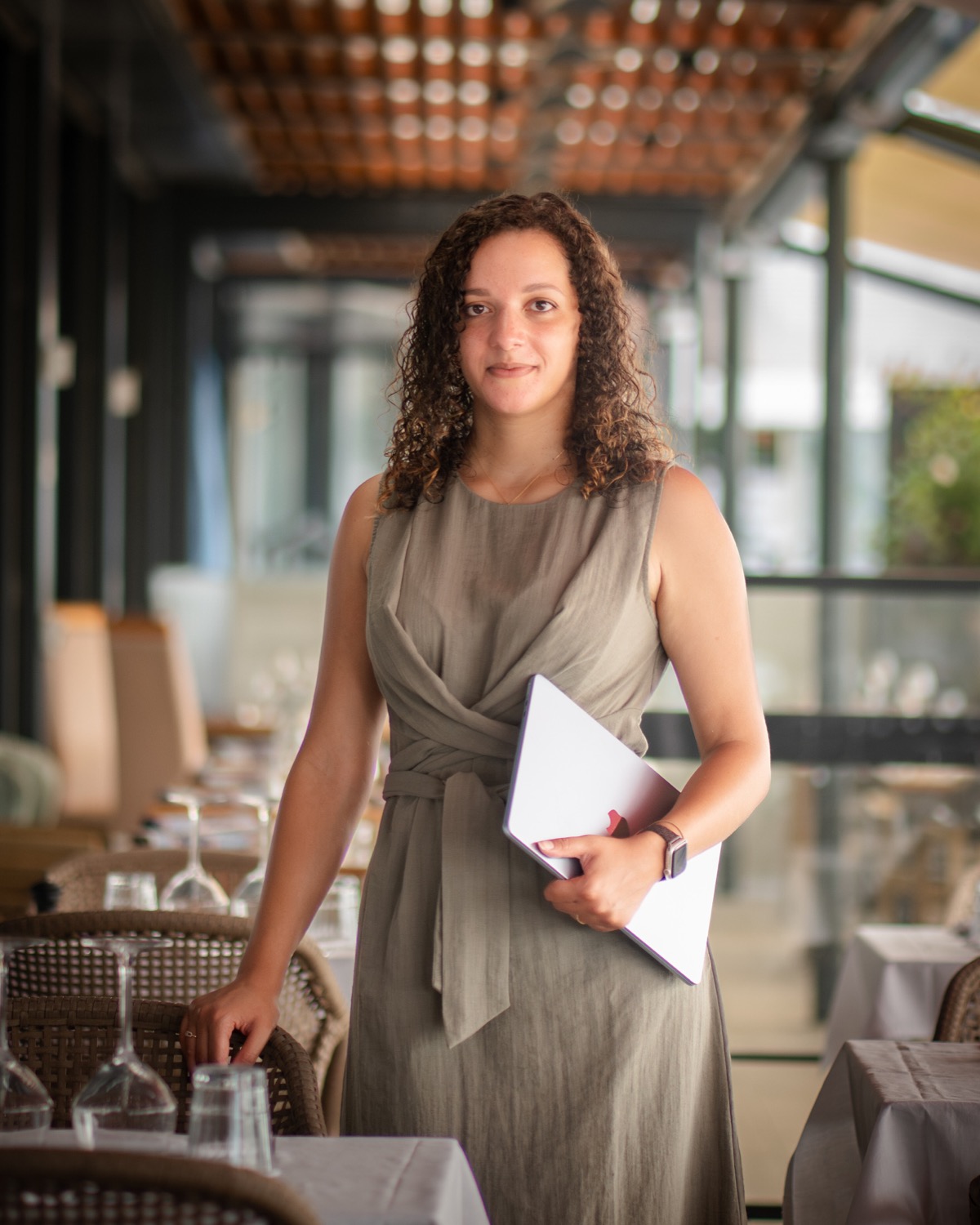 Aude-Lise Houdin, fondatrice de LIVIEIRA, dans un établissement, ordinateur à la main.
